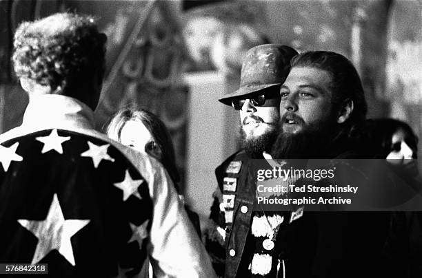 Ken Kesey[l] talks with some Hell's Angels at the Merry Pranksters' Acid Test Graduation.