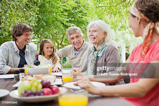 three generation family with girl (6-7 years) at garden table - 60 69 years 個照片及圖片檔