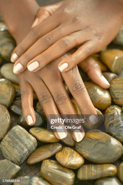 woman's hands on stones - african american nails stock pictures, royalty-free photos & images
