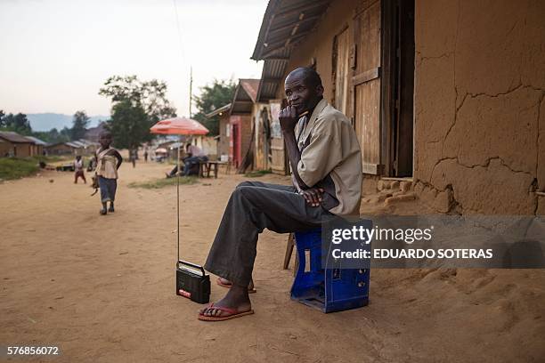 Picture taken on July 15, 2016 shows a man listening to the radio on the streets of Luofu, North Kivu province. / AFP / EDUARDO SOTERAS