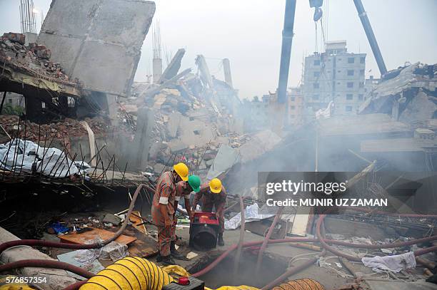 In this photograph taken on April 29 Bangladeshi firefighters try to control a blaze during a rescue attempt as Bangladeshi Army personel begin the...