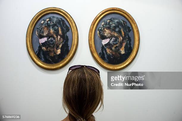 Young woman observes two of the paintings of Santiago Ydañez in the German gallery Nova Invaliden present in the edition of the international art...