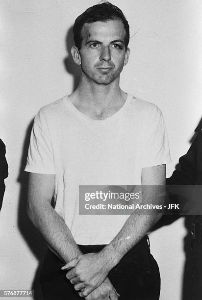 Lee Harvey Oswald stands detained by the Dallas Police Department following his arrest for possible involvement in the John F. Kennedy assassination...