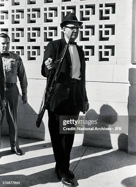 An investigator removes from the Texas School Book Depository the rifle allegedly used to assassinate President Kennedy.