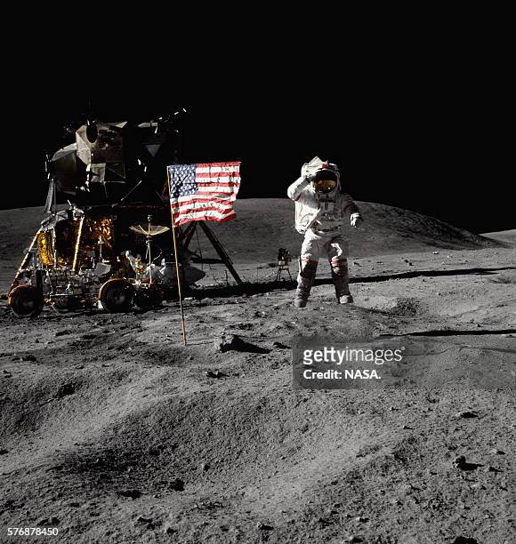 Astronaut John W. Young throws a salute to the flag, in Descartes Crater, on the surface of the Moon. The Apollo 16 lunar module Orion and lunar...