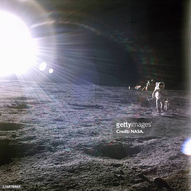 Brilliant sun shines above the Apollo 12 base on the Moon's surface. One of the astronauts walks away from the lunar module Intrepid. | Location:...