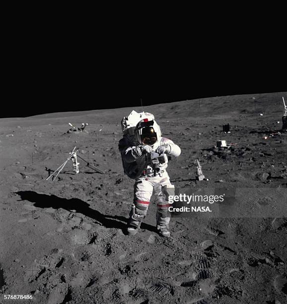 An astronaut carries a camera on the moon during the 1972 Apollo 16 mission. This mission was the first time ultraviolet camera/spectrograph was used...