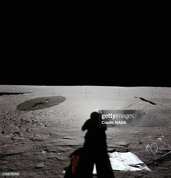 One of the Apollo 12 astronauts casts a shadow while taking a photograph on the surface of the Moon. The brightening around the astronaut's shadowed...