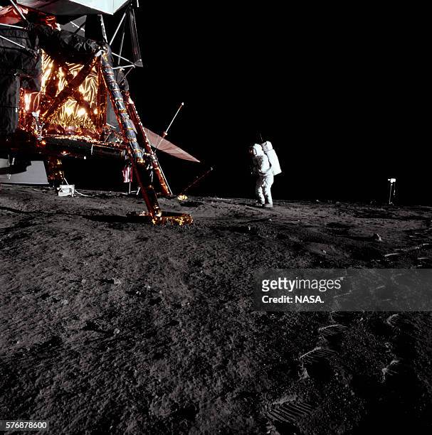 An astronaut leaves footprints on the Moon walking near the lunar module Intrepid during the Apollo 12 mission. | Location: Oceanus Procellarum, Moon.