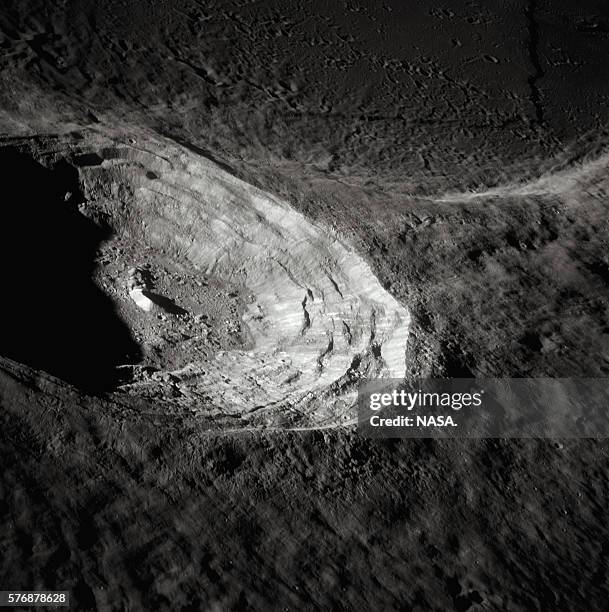 Bright impact crater contrasts with the surrounding area on the Moon, as seen from the Apollo 15 spacecraft. | Location: Moon orbit.