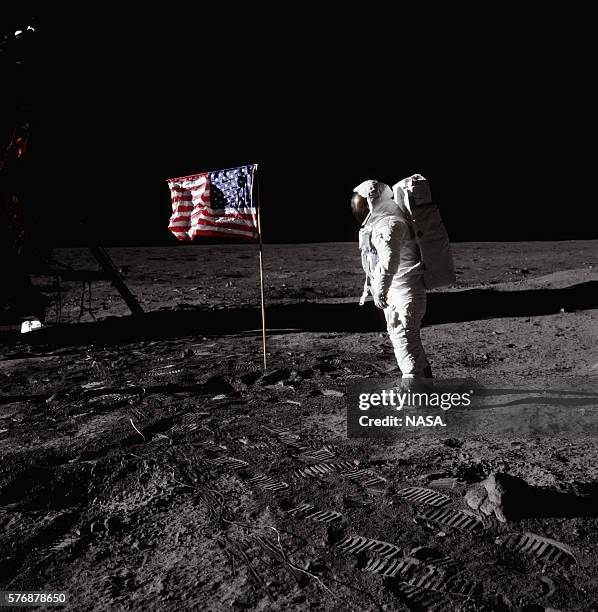 Buzz Aldrin stands beside an American flag at Tranquility Base on the surface of the moon during the Apollo 11 mission.