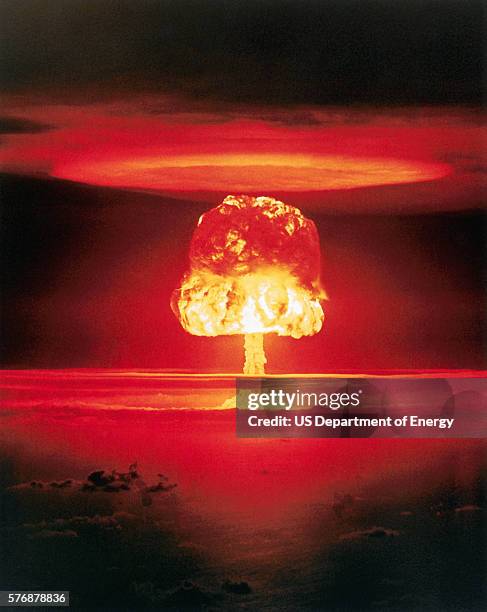 Fiery mushroom cloud rises into the sky following the test detonation of an 11-megaton nuclear device code named "Romeo" over Bikini Atoll on March...