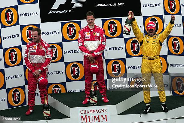 Winner Michael Schumacher, center, second place driver Rubens Barrichello, left, and third place finisher Tiago Monteiro during a subdued victory...