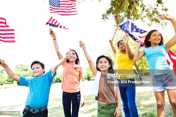 diverse american kids wave american flags - parade stock pictures, royalty-free photos & images