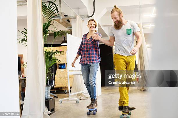 employees skating through the office - couple skating stock pictures, royalty-free photos & images