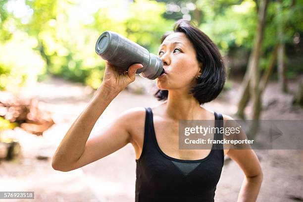 woman refreshment herself on the nature after have been hiking - water canteen stock pictures, royalty-free photos & images