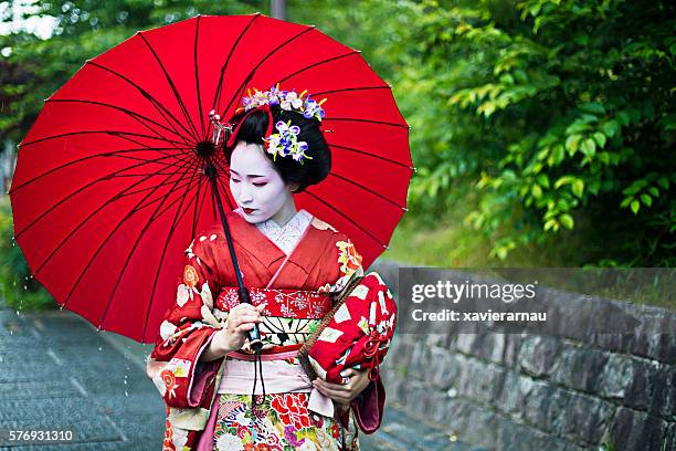 wunderschöne haltestelle maiko in den straßen von kyoto - papierschirm stock-fotos und bilder