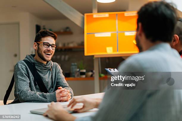 hombre joven en una entrevista de trabajo. - búsqueda de trabajo fotografías e imágenes de stock