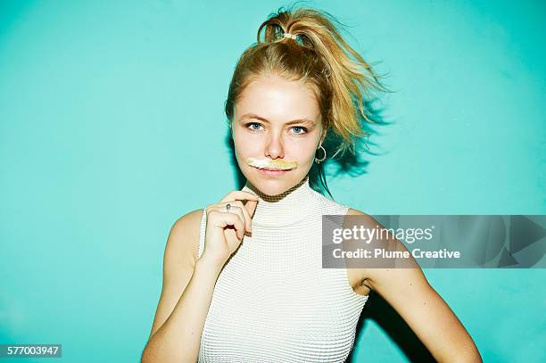 young woman posing with silly mustache. - facial hair in women stock pictures, royalty-free photos & images