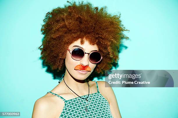 woman being silly and wearing a stick on mustache. - dress up stock pictures, royalty-free photos & images