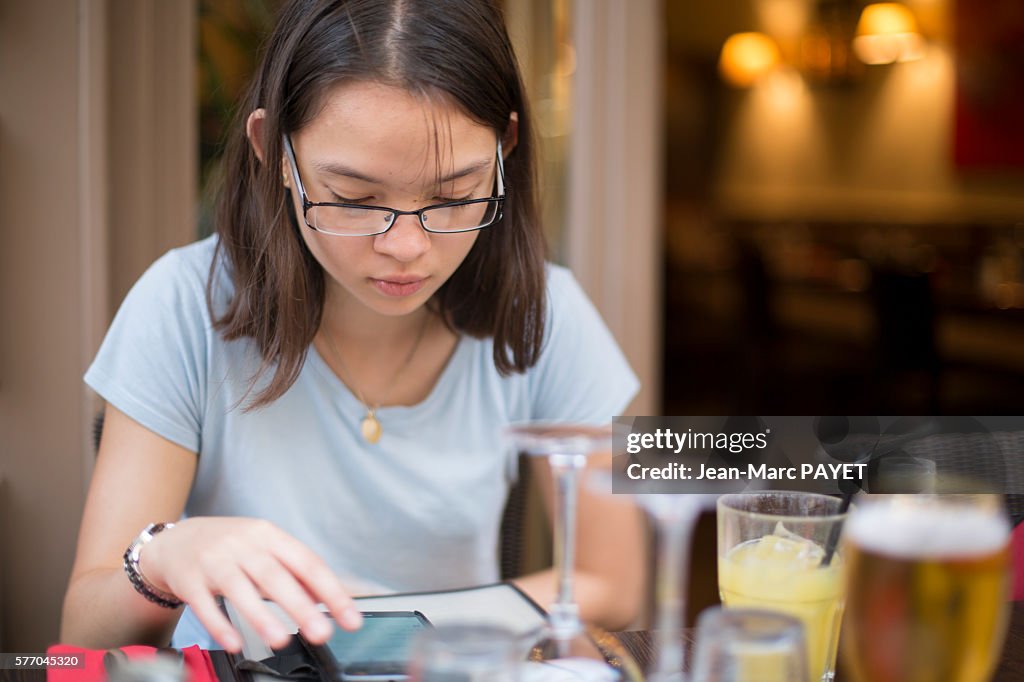 Young girl with a phone in a restaurant