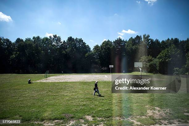 An asylum-seeker from Syria walks by a makeshift basketball court on a helicopter pad at the asylum-seekers' hostel run by the Federal Office for...