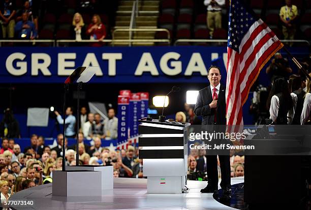 Reince Priebus, chairman of the Republican National Committee, takes part in the national anthem on stage before the start of the first day of the...