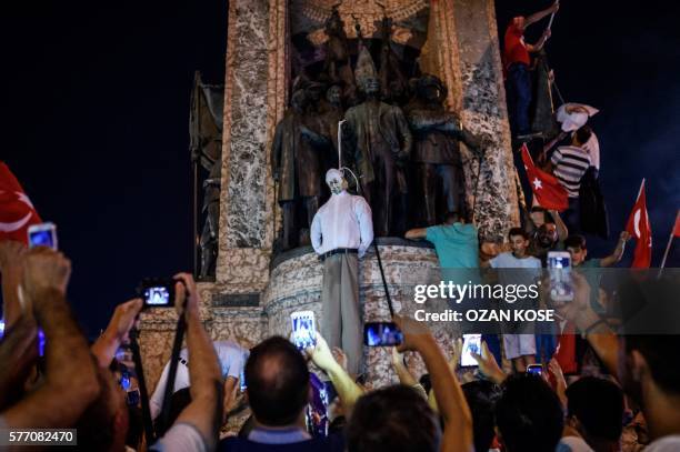 Pro-Erdogan supporters hold an effigy of US-based preacher Fethullah Gulen hunged by a noose during a rally at Taksim square in Istanbul on July 18,...