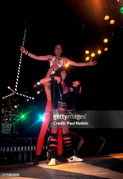 American Rock musician Kevin DuBrow sits atop the shoulders his bandmates Carlos Cavazo and Frankie Banali, all of the band Quiet Riot, as they...