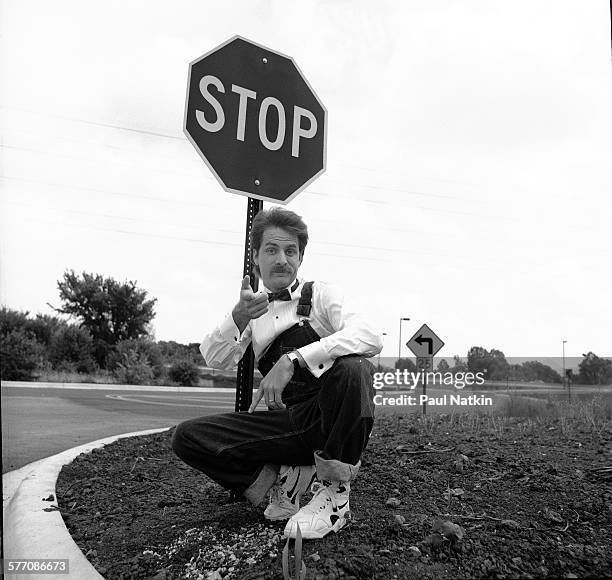 Portrait of American comedian Jeff Foxworthy as he poses beside a stop sign on the side of the road, Chicago, Illinois, July 12, 1993.