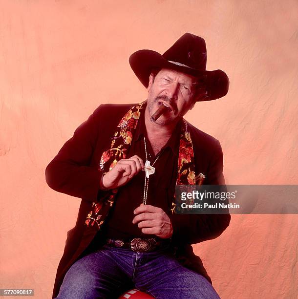 Portrait of American musician, author, and comedian Kinky Friedman as he poses backstage during the Farm Aid benefit concert at Texas Stadium,...