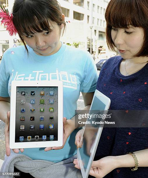 Japan - Women hold Apple Inc.'s iPad 2 tablet computers in front of an Apple store in Tokyo's Ginza shopping district on April 28 as the new version...