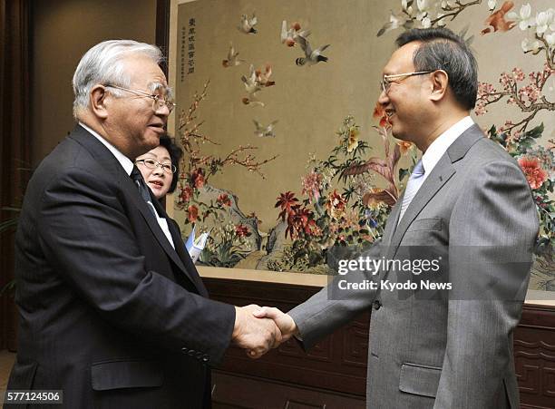 China - Japan Business Federation Chairman Hiromasa Yonekura and Chinese Foreign Minister Yang Jiechi shake hands at the ministry building in Beijing...