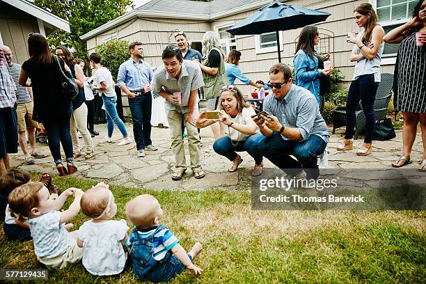 parents taking pictures with smartphones of babies - bush baby bildbanksfoton och bilder