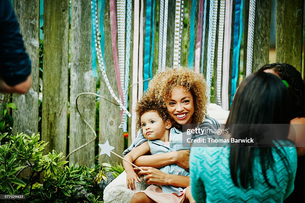 Smiling mother embracing toddler daughter