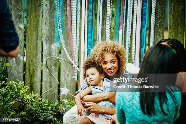 Smiling mother embracing toddler daughter