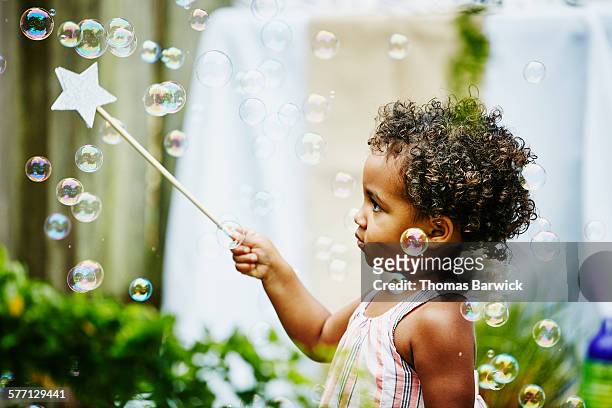 toddler girl with star wand playing with bubbles - bubble wand photos et images de collection