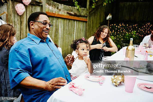 laughing grandfather sitting with family - milestone stockfoto's en -beelden