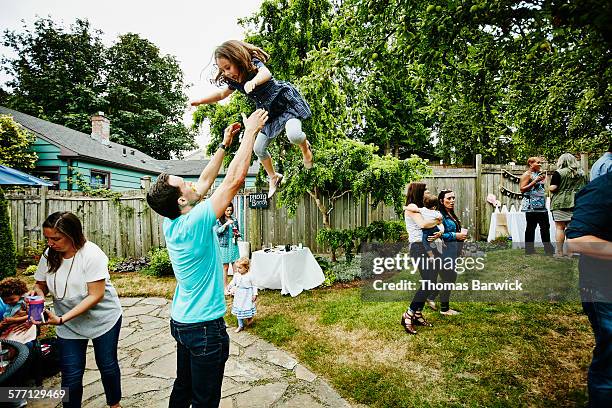 laughing young girl being thrown up in the air - bush live stock-fotos und bilder