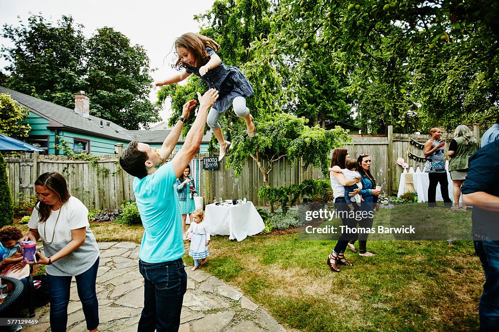 Laughing young girl being thrown up in the air