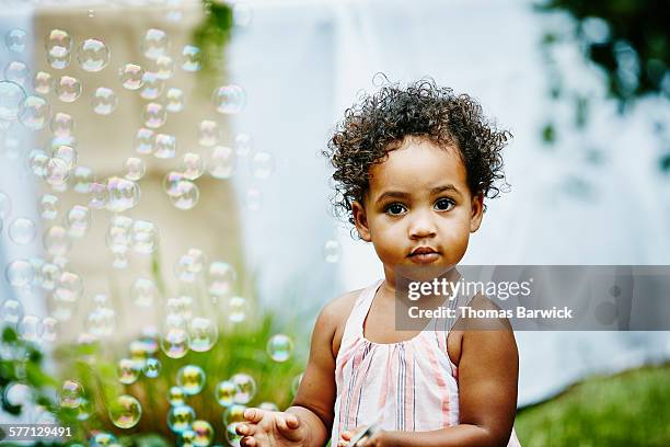 toddler girl playing with bubbles in backyard - basic instinct 2 stock pictures, royalty-free photos & images