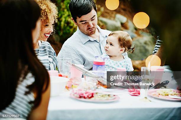 father holding infant daughter at table - eenjarig plantenkenmerk stockfoto's en -beelden