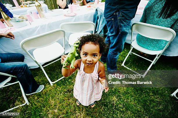 toddler girl playing with toy during party - eenjarig plantenkenmerk stockfoto's en -beelden