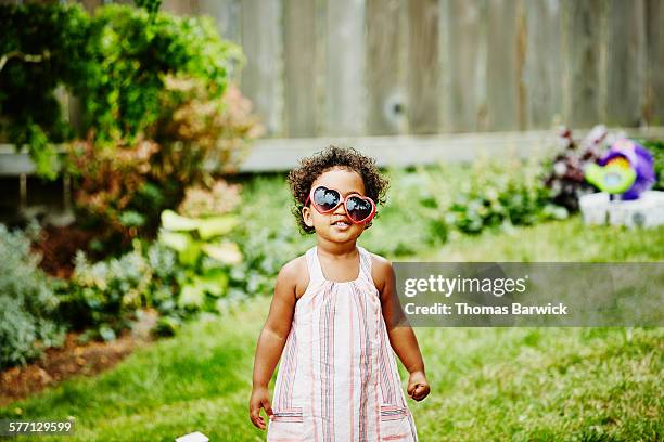 smiling girl with crooked sunglasses on face - toddler girl dress stockfoto's en -beelden