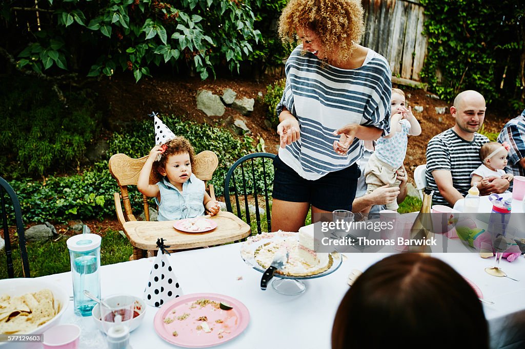 Toddler eating cake during birthday party