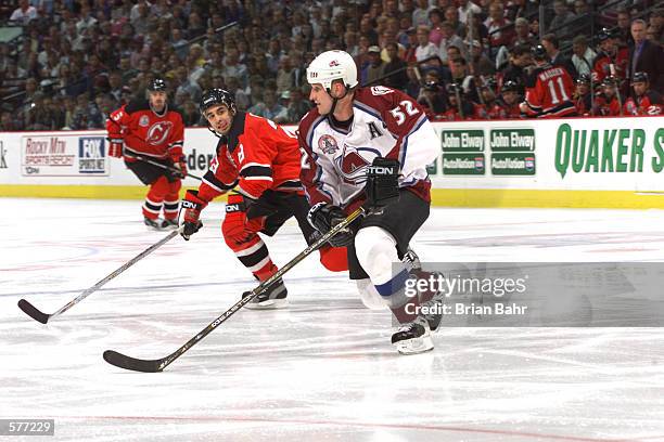 Scott Gomez of the New Jersey Devils gives chase as Adam Foote of the Colorado Avalanche takes the puck during the third period in game 2 of the NHL...