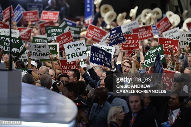 Delegates hold signs on the first day of the Republican National Convention on July 18, 2016 at the Quicken Loans Arena in Cleveland, Ohio. The...