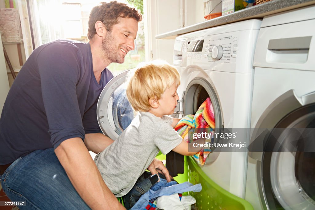 Father and son loading washing machine