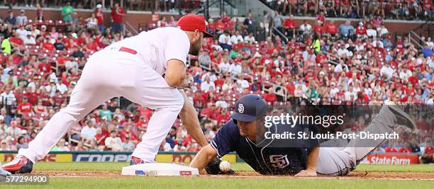 St. Louis Cardinals first baseman Matt Holliday is unable to catch the pickoff throw from pitcher Mike Leake as San Diego Padres' Alex Dickerson...