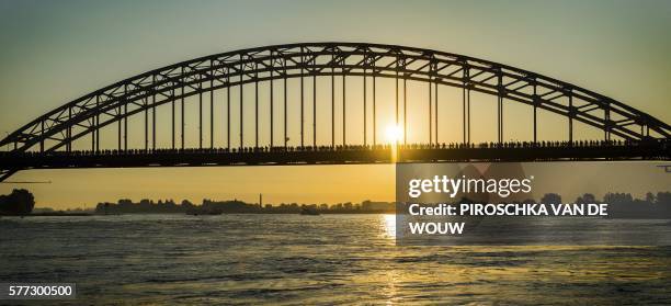 Participants cross a bridge over the Waal river during the first day of the 100th edition of the annual four days march of Nijmegen, on July 19,...